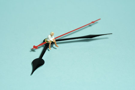 Miniature tiny people toy figure photography. A girl teenager sitting above clockwise. Isolated on...