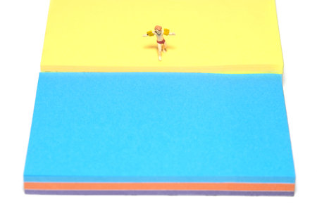 Creative miniature people toy figure photography. Sticky notes installation. Kids with arm buoy walking at beach shore to swim. Isolated on white background. Image photoの写真素材