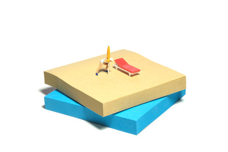 Creative miniature people toy figure photography. Sticky notes installation. A girl preparing umbrella beside beach bench to relaxing at the beach. Isolated on white background. Image photoの写真素材
