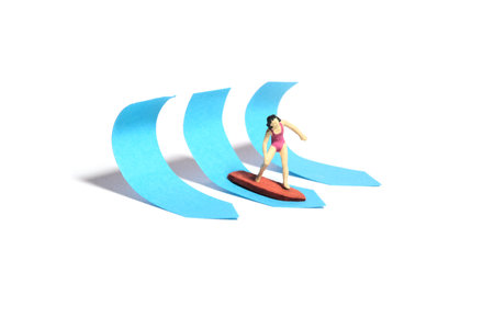 Creative miniature people toy figure photography. Sticky notes installation. A girl surfer riding big waves on surfing board. Isolated on white background. Image photoの写真素材