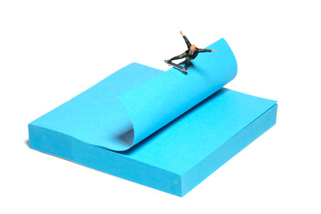 Creative miniature people toy figure photography. Sticky notes installation. A men skater playing skateboarding sport at skate park. Isolated on white background. Image photoの写真素材