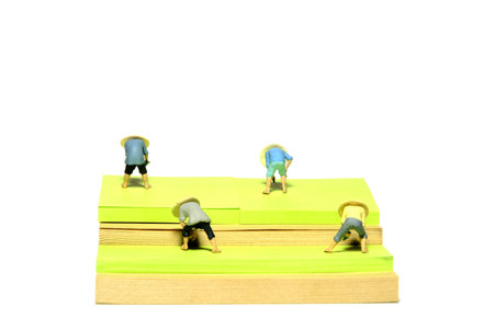 Creative miniature people toy figure photography. Sticky notes installation. Group of farmers harvest and planting on the field. Isolated on white background. Image photoの写真素材