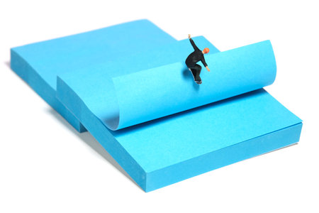 Creative miniature people toy figure photography. Sticky notes installation. A men skater playing skateboarding sport at skate park. Isolated on white background. Image photoの写真素材