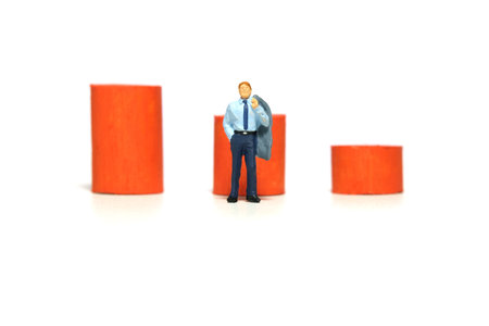 Miniature tiny people toy figure photography. Business failure concept. A businessman standing in...
