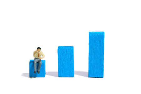 Miniature tiny people toy figure photography. Telephone marketing growth concept. A businessmen make a phone call above bar chart. Isolated on a white background. Image photoの写真素材