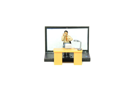 Miniature tiny people toy figure photography. Office worker illustration concept. Front view, a businessman make a phone call with laptop notebook behind. Image photoの写真素材