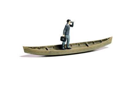 Miniature tiny people toy figure photography. Business opportunity concept illustration. Businessman using binocular telescope sail with boat. Isolated on a white background. Image photoの写真素材