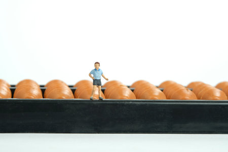 Miniature people toy figure photography. Fun learning concept. Kids play together in front of Abacus or Swipoa, math counting tool. Isolated on white background. Image photoの写真素材