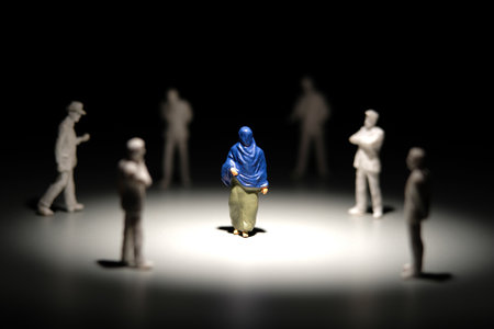 Miniature people toy figure photography. Women moslem discrimination. A women wearing niqab or veil walking in the middle of white businessman crowd. Image photoの写真素材
