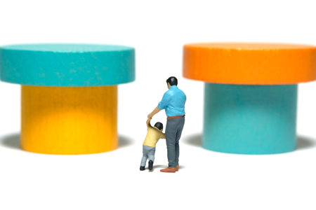 Miniature people toy figure photography. A father and son walking in front of montesorri, wooden block. Isolated white background. Image photoの写真素材