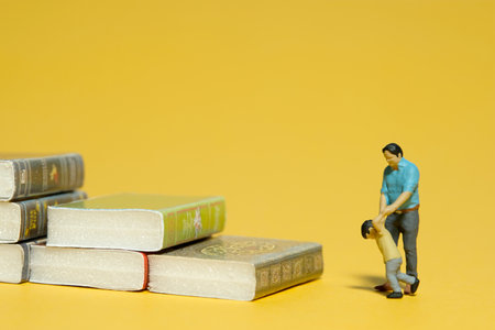 Miniature people toy figure photography. Kids education concept. A father and son standing in front...