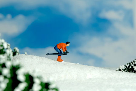 Miniature people toy figure photography. Winter sport. A male downhill ski racer slides down from the top of the hill. Image photoの写真素材