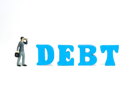 Miniature people toy figure photography. A businessman using binocular telescope standing beside DEBT wood word letter. Isolated on white background. Image photoの写真素材