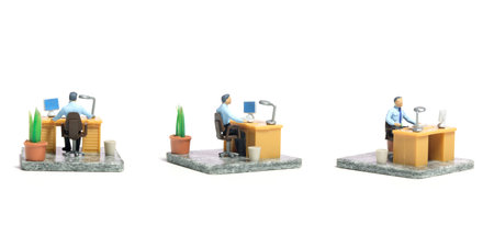 Miniature tiny people toy figure photography. Workspace station layout design concept. A businessmen seat on his desk, busy, working his job. Isolated on a white background. Image photoの写真素材