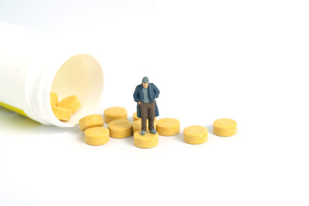 The man with no money can't pay the medical bills, drug pill receipt. Miniature tiny people toys photography. isolated on white background.の写真素材
