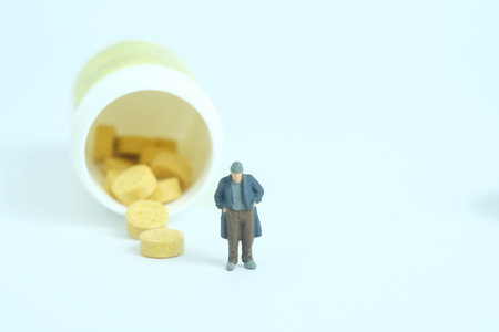 The poor man with no money can't pay the medical bills, drug pill receipt. Miniature tiny people toys photography. isolated on white background.の写真素材