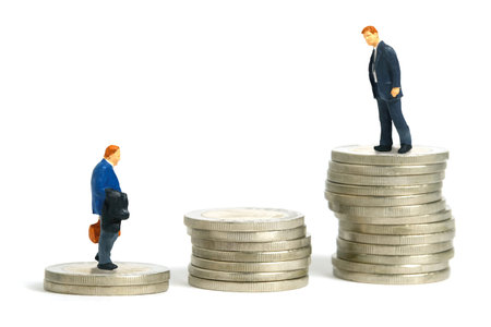 Miniature people toy figure photography. Two businessmen standing above stairs made from coin pile. Isolated on white background. Image photoの写真素材