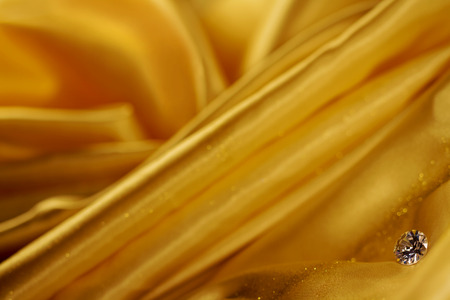 Beautiful big diamond jewelry on golden satin cloth background. Fine natural precious stoneの写真素材