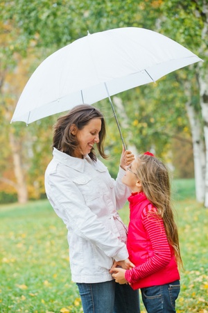  Cute girl with her mother walking in parkの写真素材