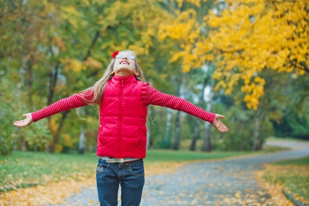  Cute girl walking in the autumn parkの写真素材