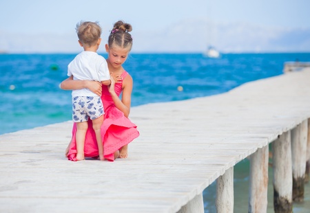 Girl with her brother walking on jettyの写真素材