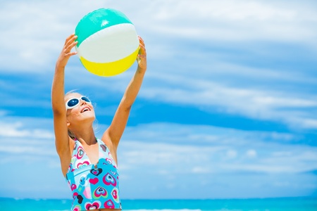 Girl with ball on the beach