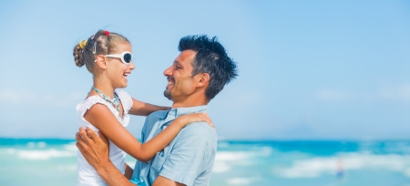 Father and daughter having fun on beachの写真素材