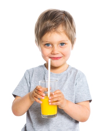 Portrait of little boy drinking orange juiceの写真素材
