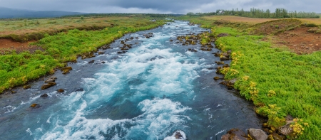 Glacier great fast blue river with green banks in Icelandの写真素材