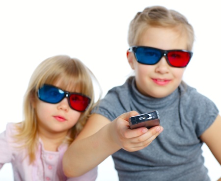 Studio shot of two girls in 3d glasses with control panel watching TV  Focus on the control panel ...