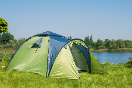 Holiday camping - Green camping tent on sunny grasslandの写真素材