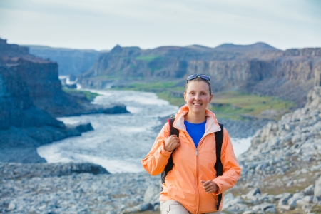 Cute woman hiking in the canyon Dettifoss waterfall in Vatnajokull National Park, Northeast Iceland の写真素材