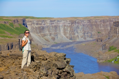 View of woman walking near famous Dettifoss waterfall in Vatnajokull National Park, Northeast Icelandの写真素材