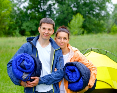 Young happy couple camping near tent in parkの写真素材