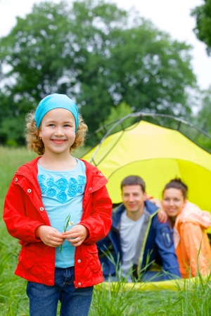 Young girl with his family near tent in camping on the natureの写真素材
