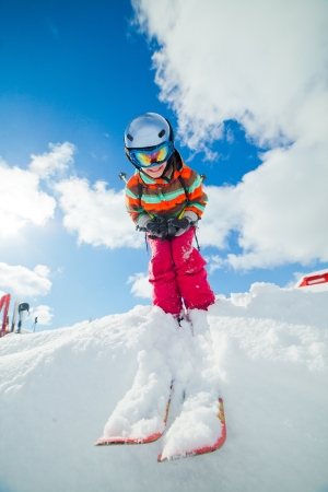 Girl on skis in soft snow on a sunny day in the mountainsの写真素材