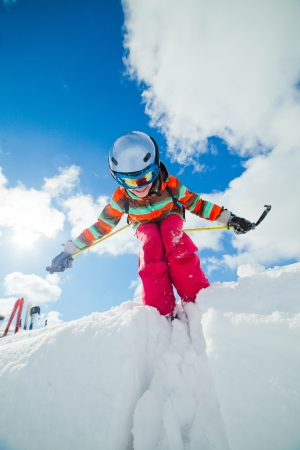 Girl on skis in soft snow on a sunny day in the mountainsの写真素材