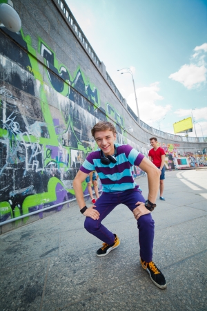 Happy teens boy with his friends by painted wall looking at camera  Vertical viewの写真素材