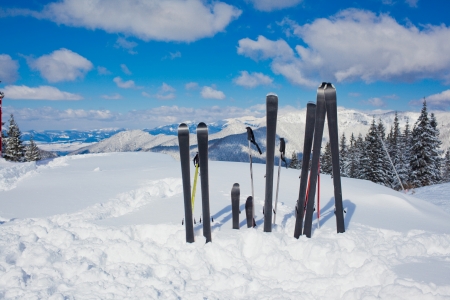 A family set of skis, ski poles in the snow mountains の写真素材