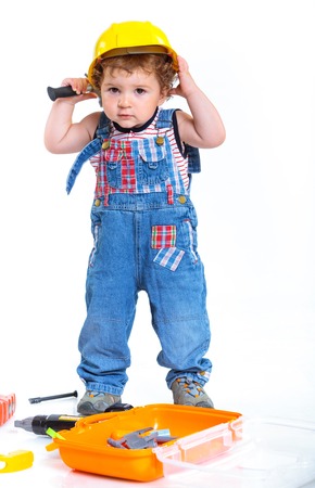 Little builder  Baby boy in a helmet plays in the builder with tools  Isolated over white の写真素材