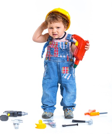 Little builder  Baby boy in a helmet plays in the builder with tools  Isolated over white の写真素材