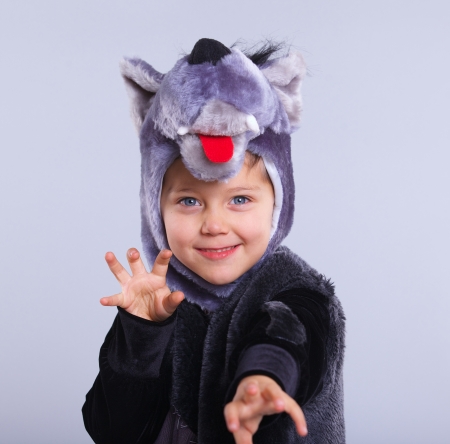 A portrait of a little boy trying a carnival suit of wolf on the grey の写真素材