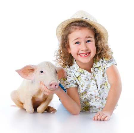 Little farmer  Cute girl with pig  Isolated on white background の写真素材