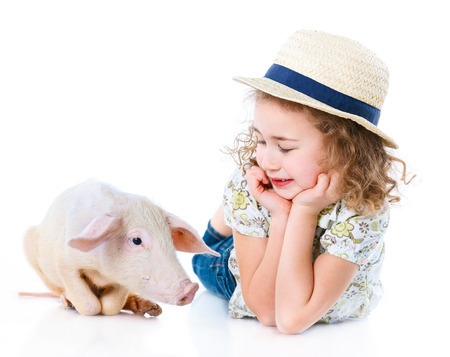 Little farmer. Cute girl with pig. Isolated on white background.の写真素材