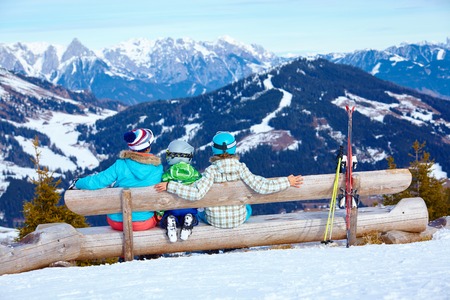 Ski, winter, snow, skiers, sun and fun - Two happy kids with mother enjoying winter vacations.の写真素材