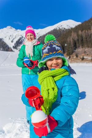 Little boy with his sister having fun in the snowの写真素材