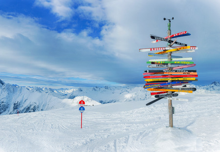 Crossroad sign in the Alps pointing to international cities, Ischgl, Austria.の写真素材