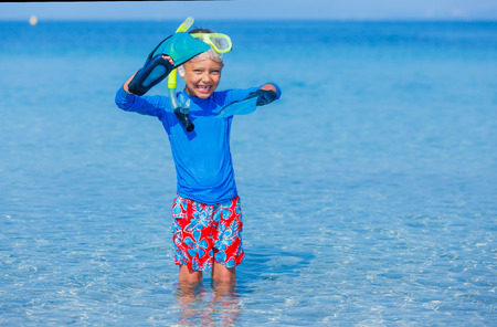Joyful boy on the tropical beach ready for scuba diving.の写真素材