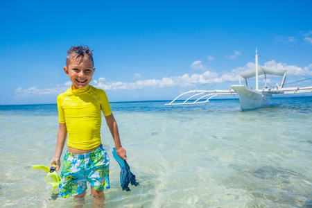 Joyful boy on the tropical beach ready for scuba diving.の写真素材