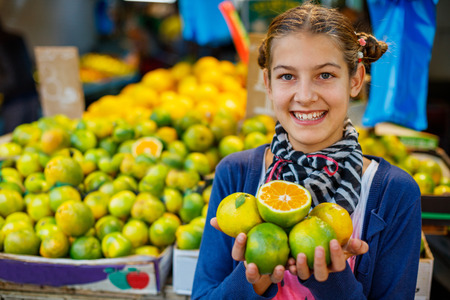 Portrait of young girl with orange on the marketの写真素材